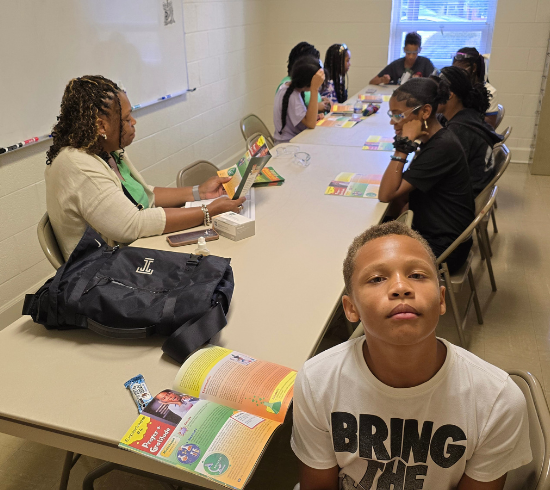 boy looking at camera with class in background