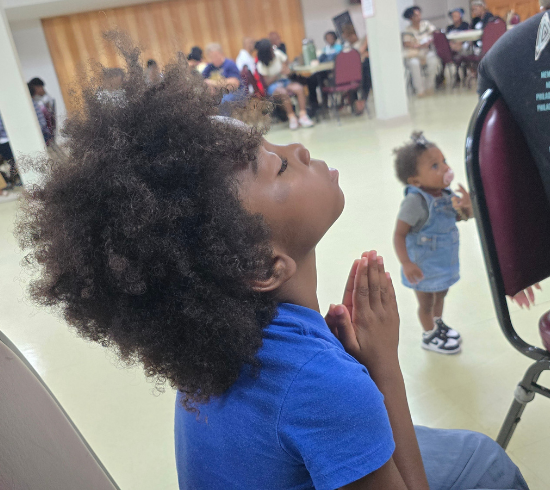 boy praying with hands folded