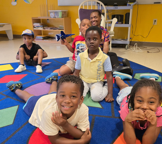 nursery students pose with teacher
